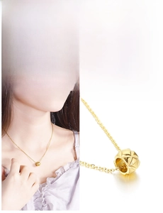 Macro shot of 18K gold plated cylindrical pendant with rhombus pattern on O-chain