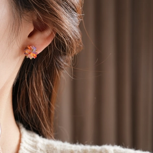 Close-up of a model wearing colorful glass flower cluster stud earrings with silver needles