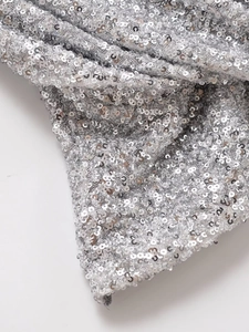Gros plan de paillettes argentées scintillantes sur tulle avec reflets métalliques