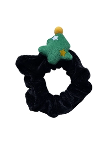 Détail d'un chouchou en velours noir avec un sapin de Noël vert en peluche et des étoiles