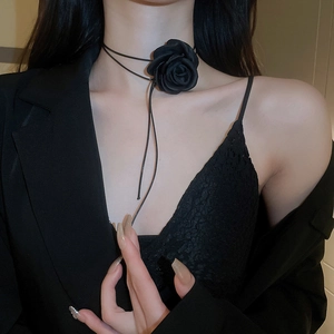 Close-up of a handmade black fabric rose choker necklace on a model for elegant styling