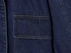 Gros plan d'une poche de jupe en jean bleu foncé avec coutures contrastées jaunes