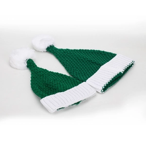 Deux bonnets de Noël tricotés vert et blanc avec pompons posés à plat sur fond