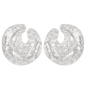 Close-up of silver earrings with irregular C-shape and hammered metal texture