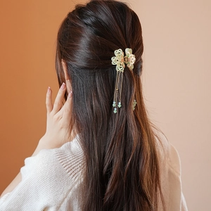 Detail of elegant floral hair claw clip with pearl tassels on a woman's hair