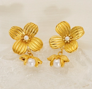 Detail of gold floral pearl earrings featuring textured petals and glossy drop pearls