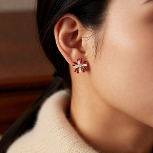 Macro detail of firework floral earring with red enamel and sparkling cubic zirconia