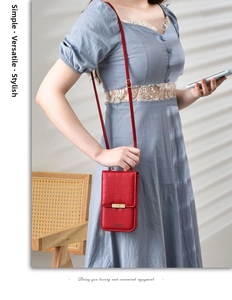 Detail of red quilted phone crossbody bag with metal lock worn on lace dress