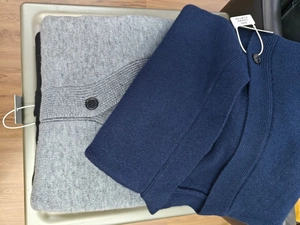 Detail of V-neck knitted cardigan with black buttons showing soft texture and fine stitching