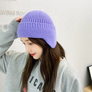 Detailed close-up of purple knitted ear protection hat with soft warm texture