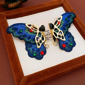 Détails macro des boucles d'oreilles papillon vintage brodées avec cristal cœur