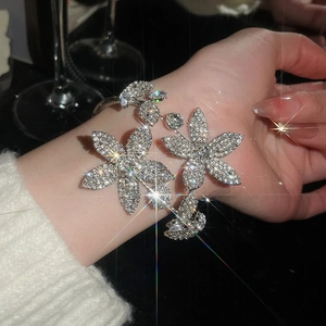 Detail of elegant silver flower open cuff bracelet with sparkling crystal pavé on wrist