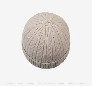 Top down view showing the thick cable knit texture and crown detail of the beige beanie