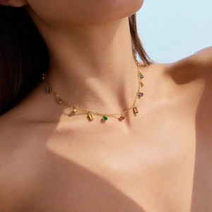 Elegante collana in acciaio al titanio dorato con gemme colorate indossata da modella
