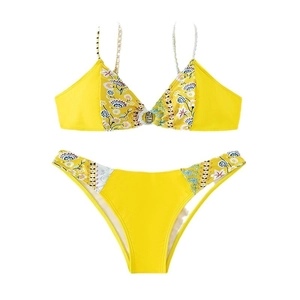 Two-piece yellow bikini set with floral print accents on a minimalist white background