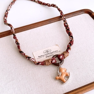 Detail of fabric woven rope and retro wooden rocking horse pendant on canvas background