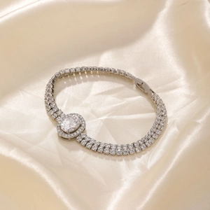 Elegant double-row diamond bracelet with an oval center stone on a silk background