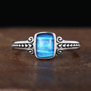 Macro shot of vintage silver ring featuring a blue rectangular stone and scroll engravings