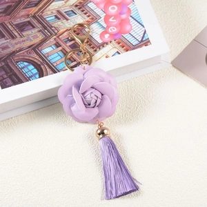 Detail of purple PU leather camellia flower keychain with silky tassel and gold hardware