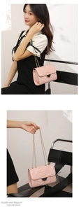 Close-up of pink quilted crossbody bag with V-shaped stitching and golden chain strap
