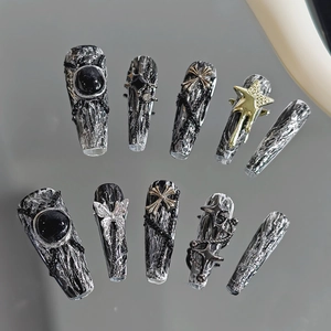 Detailed view of punk style press-on nails with silver butterflies and black gems
