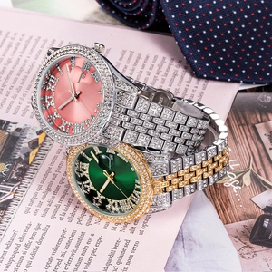 Close-up of luxury full-diamond watches with pink and green dials and steel bands