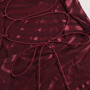 Détail de la robe en maille bordeaux avec rayures satinées et laçage