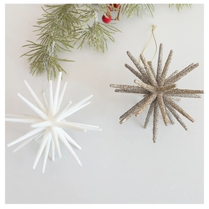 Detailed view of champagne and white glitter star ornaments on a festive pine branch