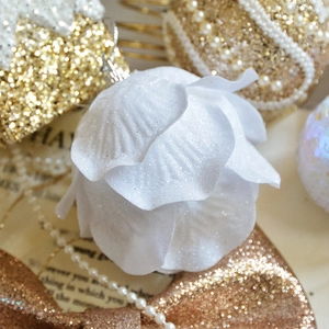 Macro shot of white glitter petal ornament with gold festive decor and pearl string