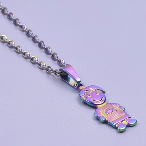 Detailed close-up of a rainbow plated little girl shaped pendant on a stainless steel chain