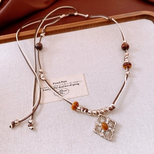 Detail of vintage necklace with amber gemstone pendant on tiger eye jewelry set