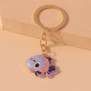 Detail of a purple and pink enamel goldfish keychain with a gold metal finish
