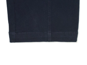 Dettaglio del tessuto in twill blu scuro e delle cuciture precise sui pantaloni casual