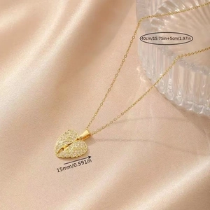 Macro shot of gold angel wing heart necklace with dimensions on silk fabric
