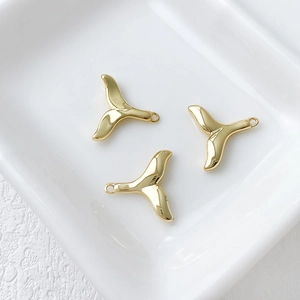 Detailed view of three 14k gold-plated whale tail charms for DIY jewelry making