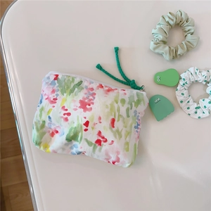 Detailed macro view of floral cotton mini pouch with green woven zipper pull cord