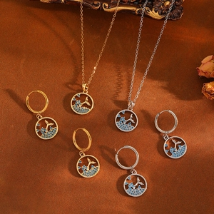 Elegant whale tail jewelry set with blue gems, necklace and earrings on vintage background