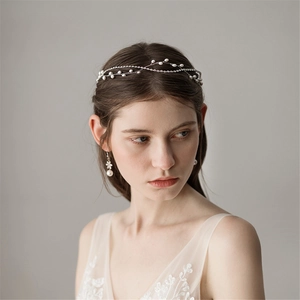 Elegant silver pearl and rhinestone bridal headband worn by a model in a soft professional setting