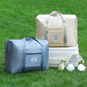 Quilted waterproof travel bag in beige and blue colors shown on a white suitcase