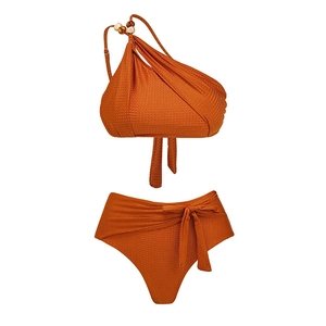 Detail of burnt orange textured bikini with one-shoulder beaded strap and high waist tie