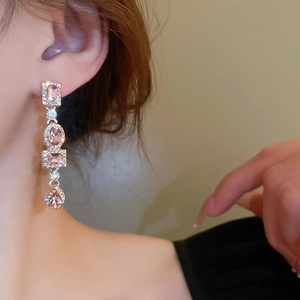 Detail of pink crystal drop earrings with sparkling rhinestones worn by a model