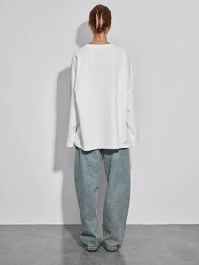Πίσω όψη από λευκό oversized βαμβακερό μακρυμάνικο T-shirt με γαλάζιο φαρδύ τζιν παντελόνι