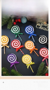 Detail of colorful Christmas swirl lollipop ornaments with festive bows and pine needles