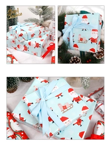 Macro shot of light blue Christmas wrapping paper with Santa and snowflake patterns