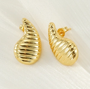 Vue détaillée de boucles d'oreilles goutte d'or 18 carats avec motif torsadé texturé
