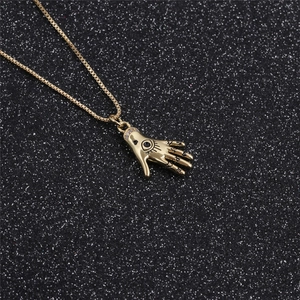 Collana con ciondolo a mano placcata oro con occhio per donna su sfondo nero glitter