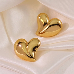 Elegant gold heart-shaped stud earrings in polished stainless steel on silk fabric