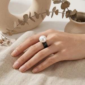 Detailed view of hammered black band ring featuring a large lustrous white pearl