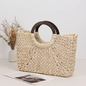 Minimalist corn husk woven beach bag with wooden handle in natural cream white color