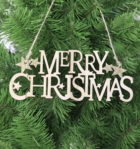 Close-up of Merry Christmas wooden letter plaque with gold glitter on pine tree branches